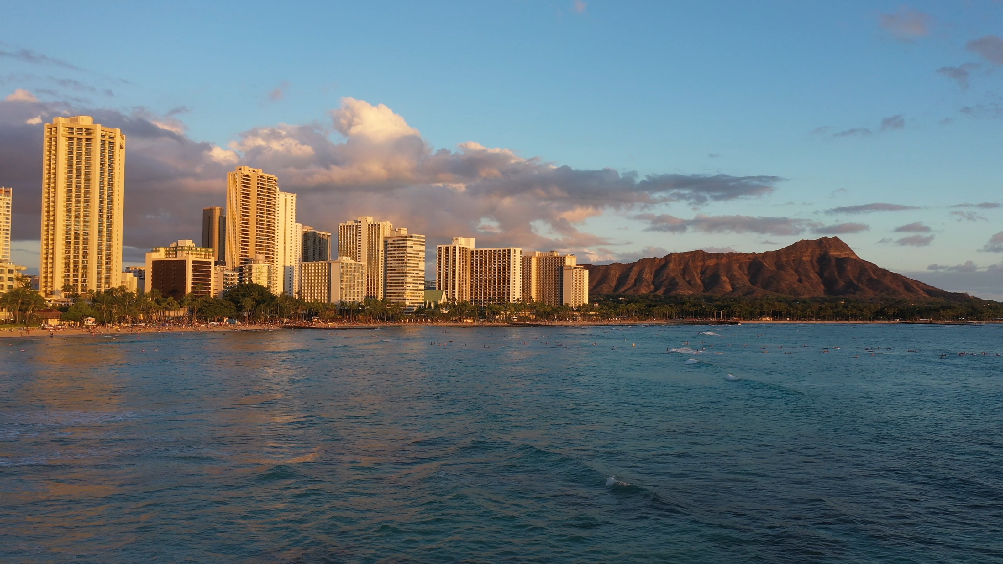 Golden hour sunset views of Waikiki Beach and Diamond Head from the ocean.
